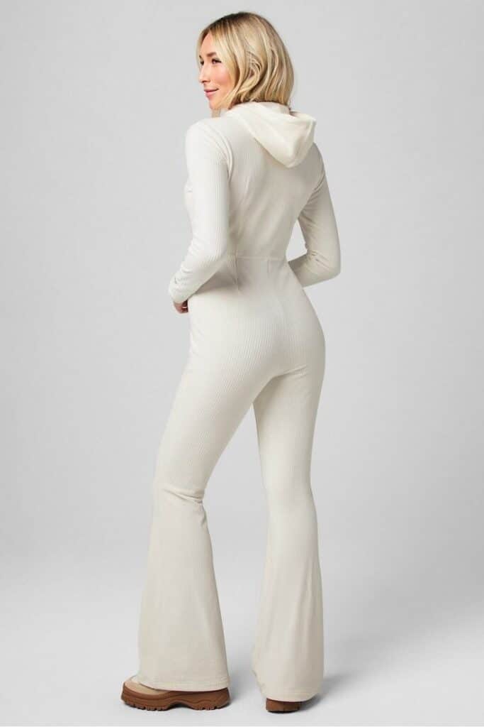 Combinaison à capuche Plush Rib Woman in a white, ribbed jumpsuit with hood, facing backwards, showcasing fashion and style with confidence. | Sky Rye Design Woman in a white, ribbed jumpsuit with hood, facing backwards, showcasing fashion and style with confidence.