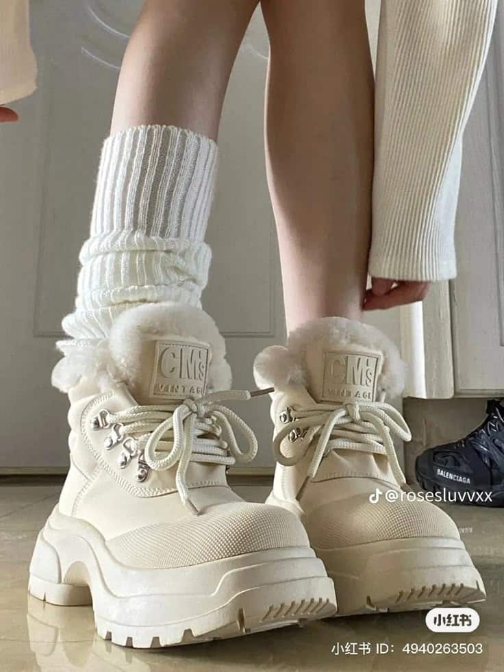 Cozy beige winter boots with fur lining and thick soles paired with chunky white socks. Stylish footwear for cold weather fashion.