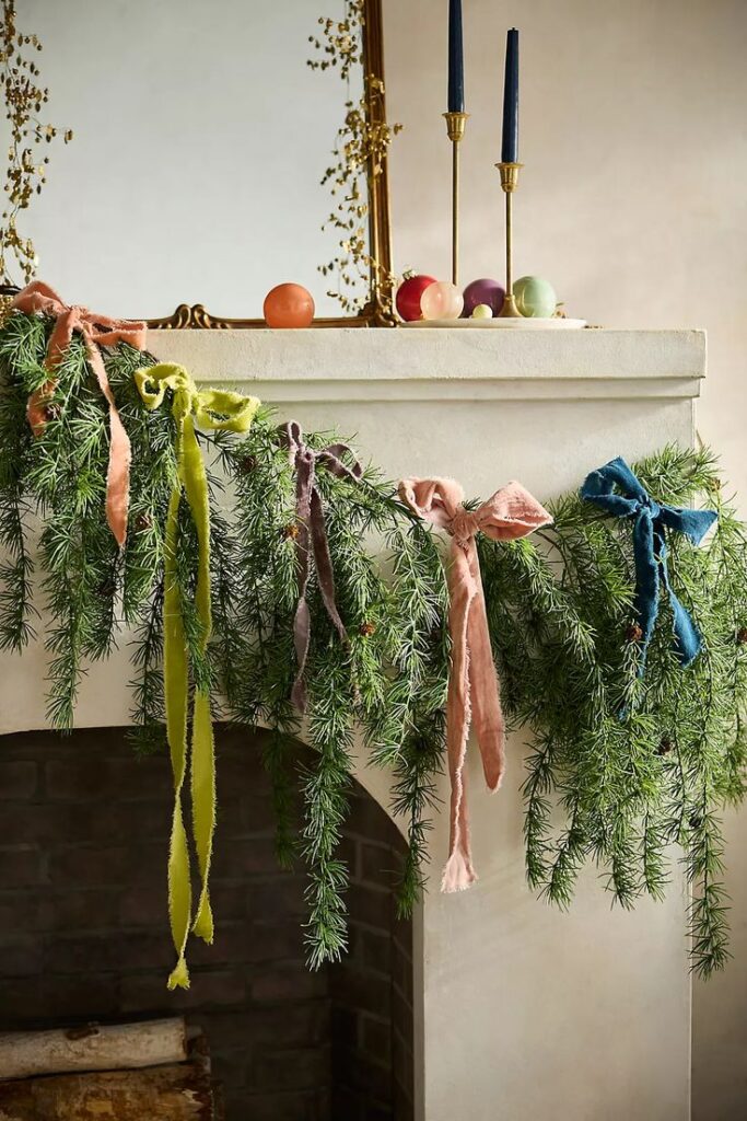 Faux Cascading Larch Garland 72 Festive mantel with evergreen garland and colorful bows, adorned with candles and decorative orbs. | Sky Rye Design Festive mantel with evergreen garland and colorful bows, adorned with candles and decorative orbs.