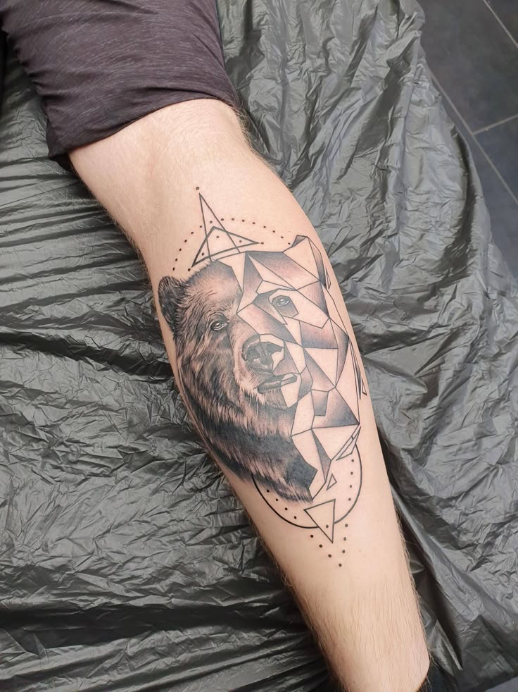 Half geometric half realistic bear made by Linda Moberg at Miks Tattoo Copenhagen tattoos tattoo beauty Geometric bear tattoo on a leg, featuring intricate line work and a blend of realism and abstract design. | Sky Rye Design Geometric bear tattoo on a leg, featuring intricate line work and a blend of realism and abstract design.