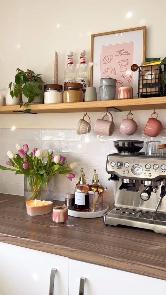 Cozy kitchen corner with tulips, coffee machine, cups, and candles on a wooden counter. Perfect space for a relaxing morning brew.