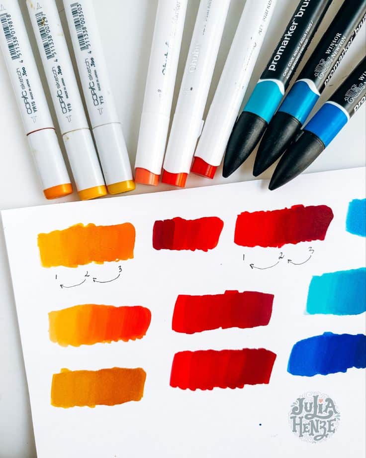 Color markers and swatches on paper showcasing gradient shades of orange, red, and blue, with hand-drawn blending arrows.