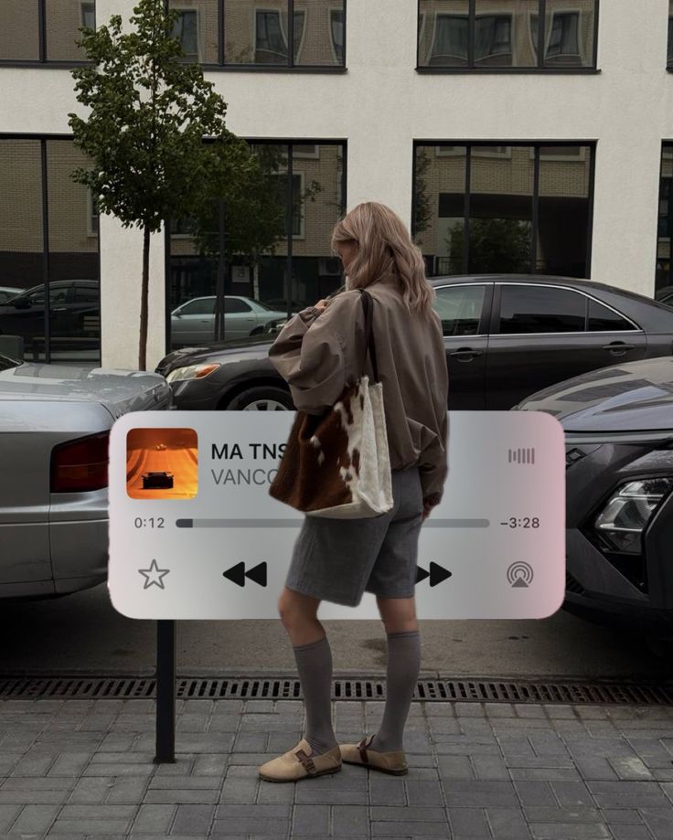 Fashionable person in urban setting with music app overlay, showcasing street style and modern tech interaction.