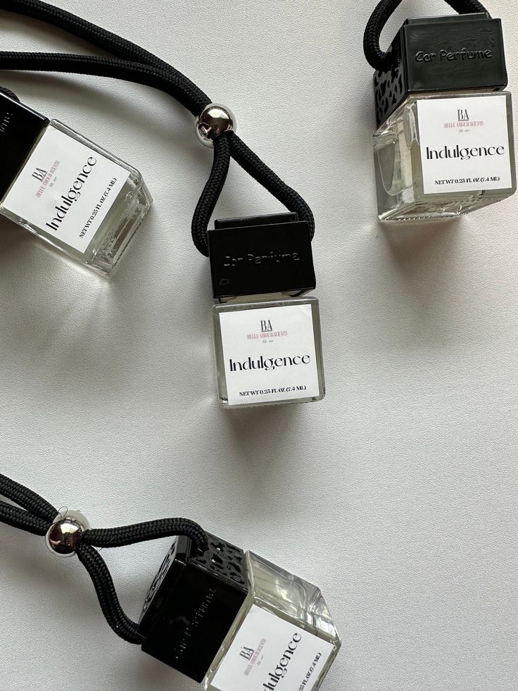 Car air fresheners with black cords and Indulgence label on a white background.
