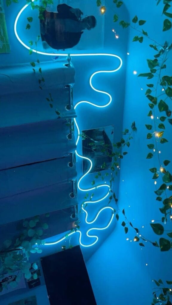 Glowing blue neon lights and green vines creating an ambient room atmosphere with reflective surfaces and soft lighting.