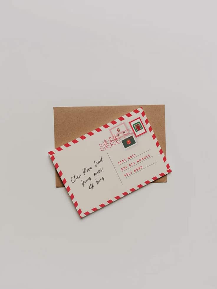 Festive letter to Santa with red-striped border and stamps, on a brown envelope, creating a Christmas holiday theme.