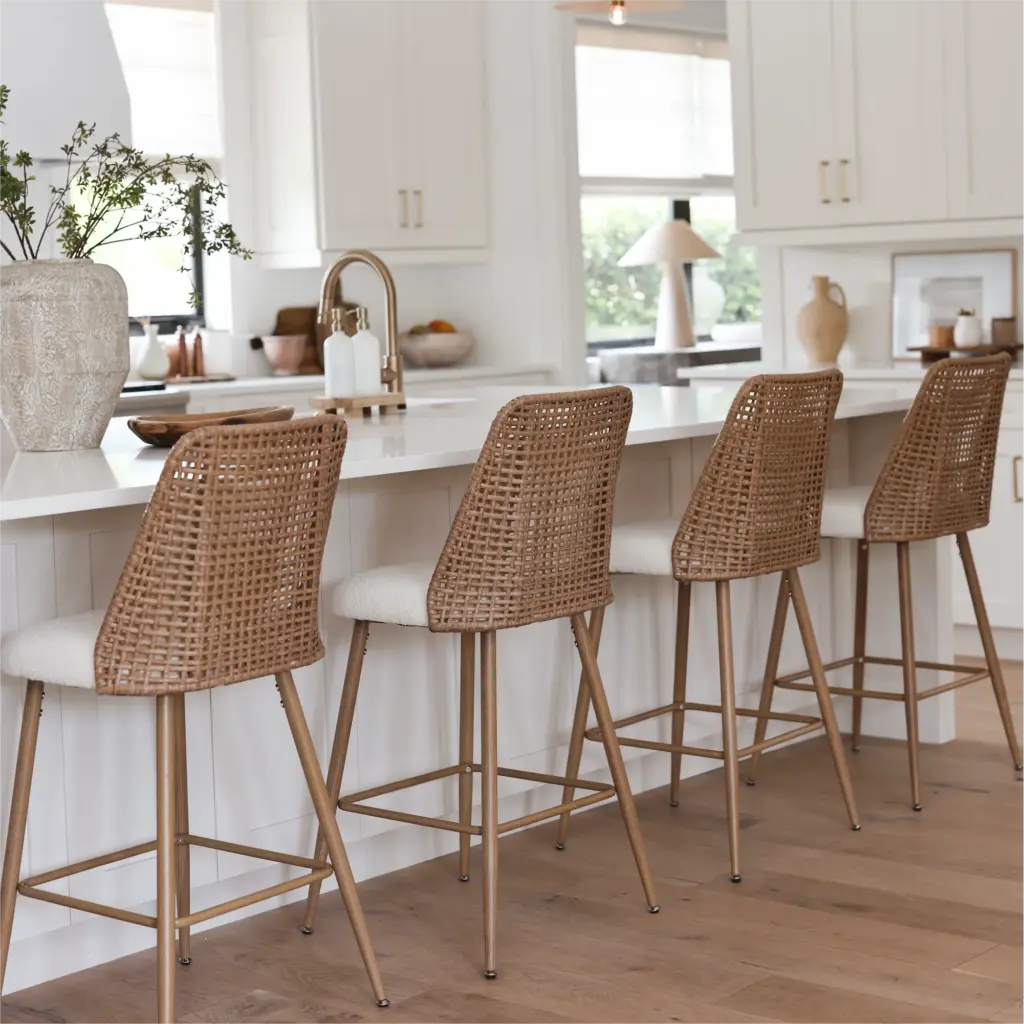 Stylish kitchen with rattan bar stools at a white island, surrounded by modern decor and wooden floor, maximizing natural light.