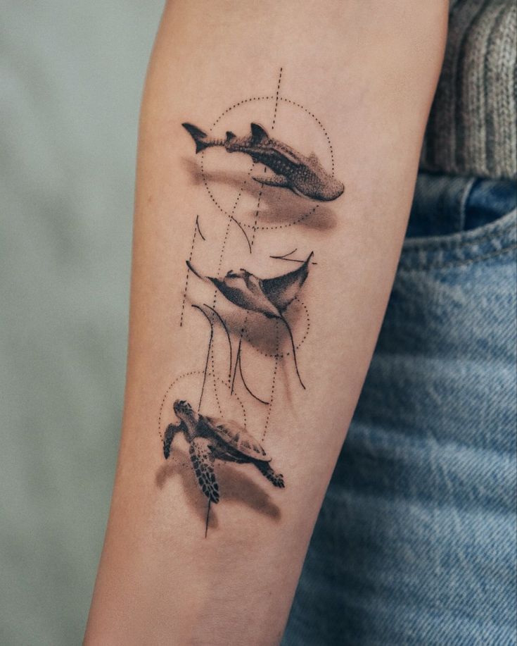 Ocean-Themed Tattoo Featuring Whale Shark Ray and Turtle for Marine Life Lovers Tattoo design of a shark, manta ray, and turtle on forearm, featuring geometric elements and detailed shading. | Sky Rye Design Tattoo design of a shark, manta ray, and turtle on forearm, featuring geometric elements and detailed shading.