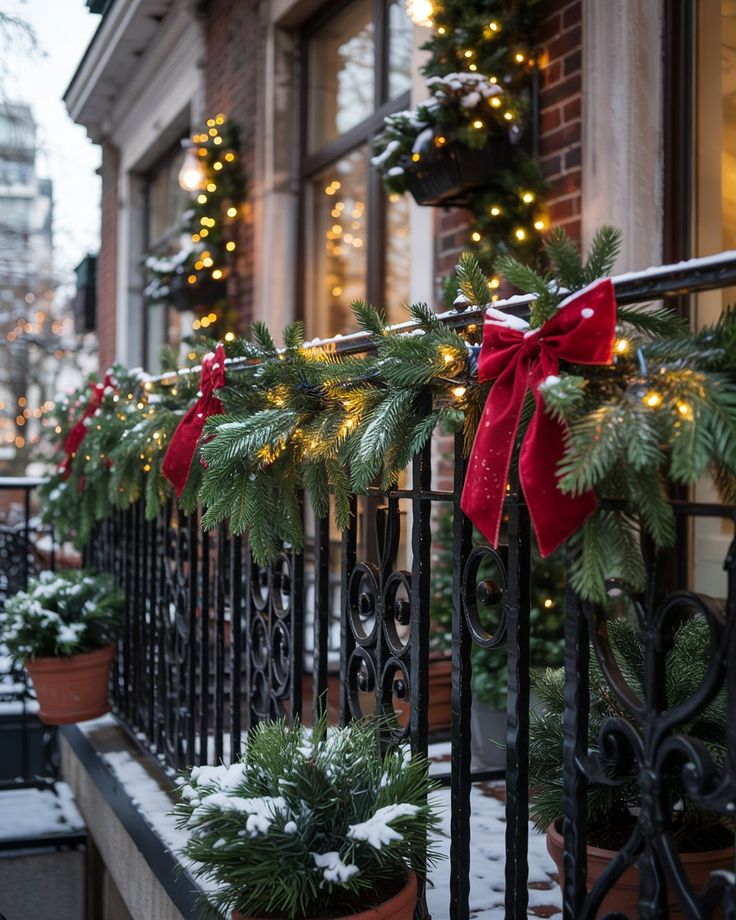 Holiday-decorated railing with evergreen garland, red bows, and twinkling lights on a snowy balcony, adding festive cheer.