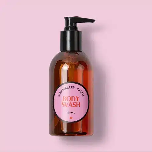 Polypropylene-Synthetic-Labels-Circle-Bodywash-Bottlejpg Strawberry cream body wash in a 125ml amber pump bottle against a pink background, offering a refreshing and fragrant bathing experience. | Sky Rye Design Strawberry cream body wash in a 125ml amber pump bottle against a pink background, offering a refreshing and fragrant bathing experience.