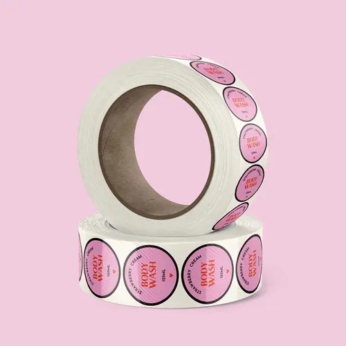 Polypropylene-Synthetic-Labels-Circle-Rolljpg Rolls of custom pink body wash stickers on a vibrant pink background, ideal for product labeling and branding. | Sky Rye Design Rolls of custom pink body wash stickers on a vibrant pink background, ideal for product labeling and branding.