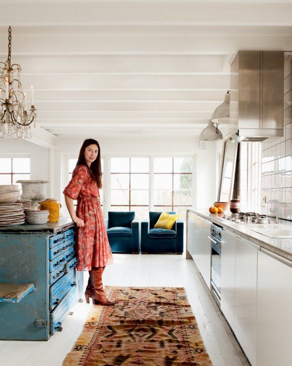 Pretty_ Stylish kitchen with woman in red dress, blue island, vintage carpet, and natural light. Unique home decor inspiration. | Sky Rye Design Stylish kitchen with woman in red dress, blue island, vintage carpet, and natural light. Unique home decor inspiration.