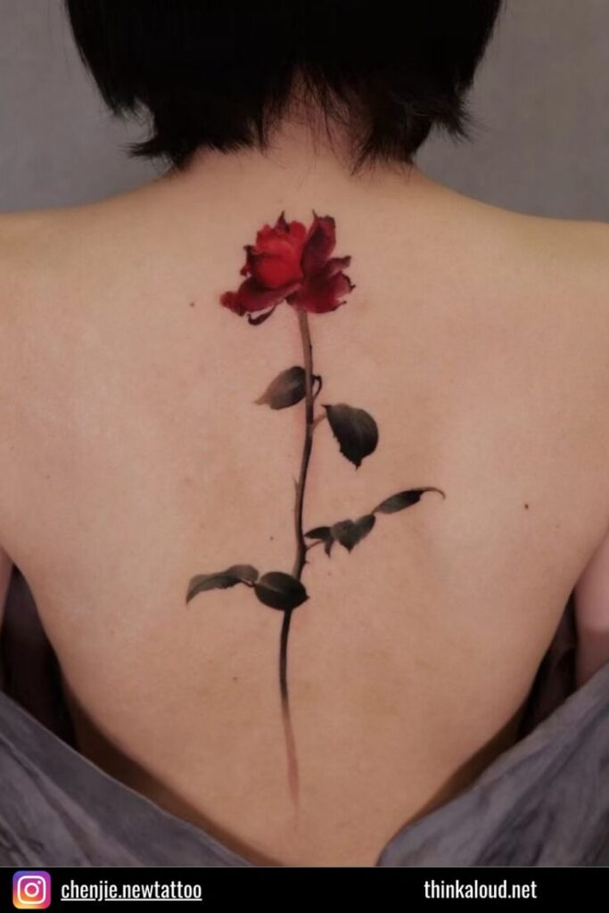 Red rose tattoo on back, artistic floral design, vibrant colors, symbol of beauty and love.