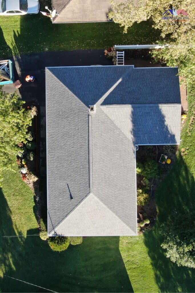 Roof Goals_ Your Roof Needs a Summer Workout Aerial view of a residential house roof with surrounding greenery and a parked car in the driveway. | Sky Rye Design Aerial view of a residential house roof with surrounding greenery and a parked car in the driveway.