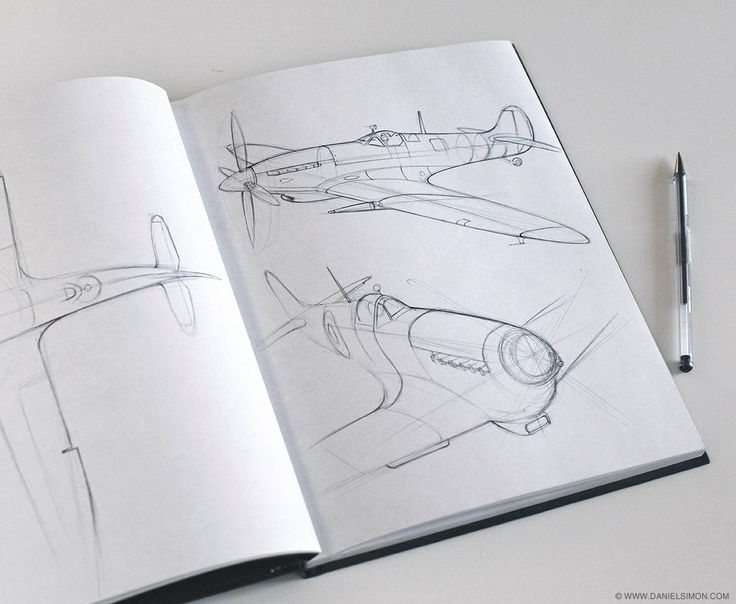 Open sketchbook with detailed airplane designs and pen on a white surface, showcasing aviation art and creativity.