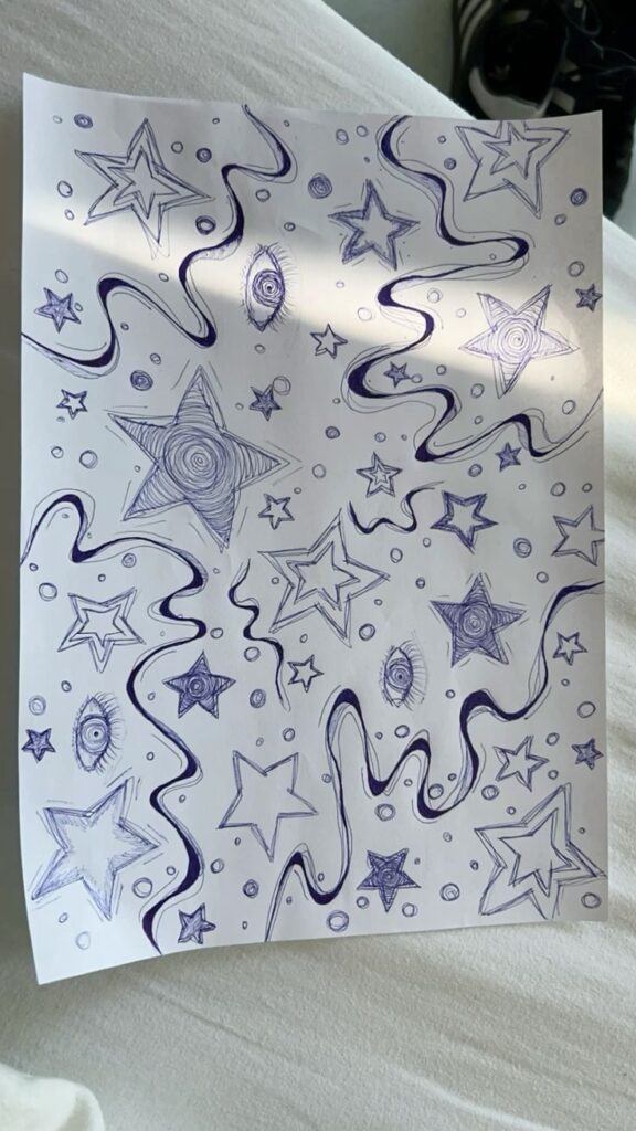 Hand-drawn stars, wavy lines, and eyes on paper, creating an abstract, whimsical pattern with pen ink art against a light background.