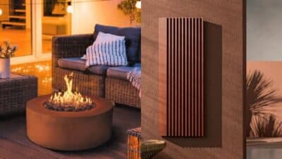 Cozy patio with modern fire pit and seating at sunset. Decorative wall panels, ambient lighting, and cushions enhance the relaxing vibe.