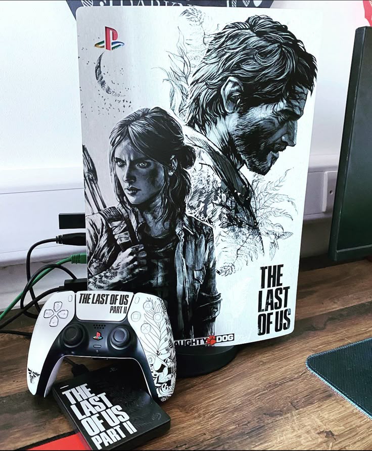 Custom PlayStation 5 with The Last of Us artwork, dualsense controller, and game case on a wooden desk setup.