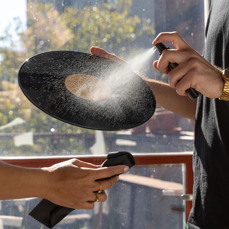 The Vinyl Record Cleaning Kit - Hammacher Schlemmer Cleaning a vinyl record with a spray bottle and cloth. Proper maintenance ensures optimal sound quality and extends record lifespan. | Sky Rye Design Cleaning a vinyl record with a spray bottle and cloth. Proper maintenance ensures optimal sound quality and extends record lifespan.