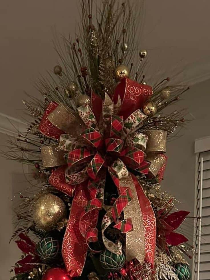 Festive Christmas tree top with red, green, and gold ribbons and ornaments, adding holiday cheer and elegance to the decor.