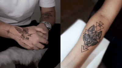 Geometric wolf forearm tattoo and abstract hand tattoo design on a person wearing a white t-shirt.