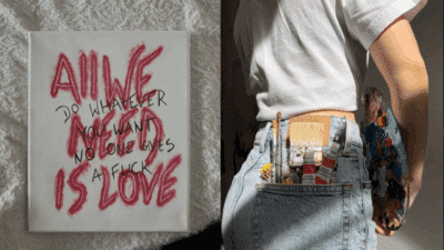 Canvas with text All We Need Is Love. Person holding a painter's palette, paint tubes in denim pocket.