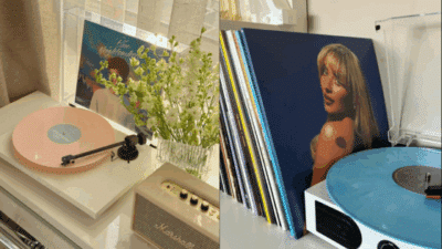 Two turntables with pastel-colored vinyl records and album covers, surrounded by flowers and a speaker, creating a cozy retro ambiance.