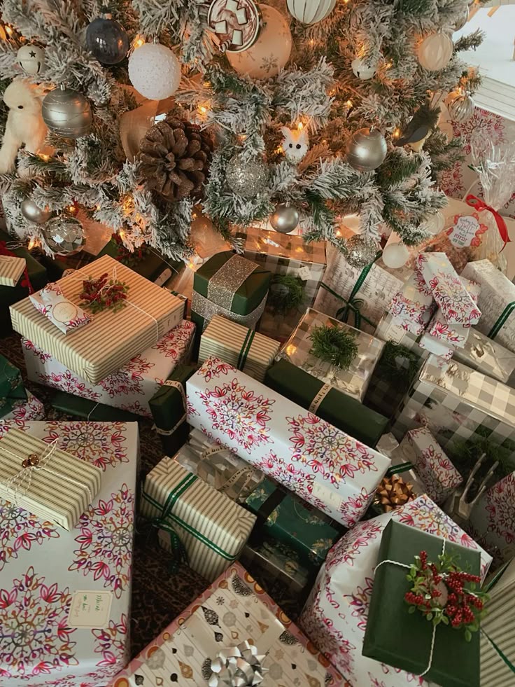 Warm green Christmas aesthetic A beautifully decorated Christmas tree surrounded by assorted wrapped gifts in festive paper and bows, creating a cozy holiday scene. | Sky Rye Design A beautifully decorated Christmas tree surrounded by assorted wrapped gifts in festive paper and bows, creating a cozy holiday scene.