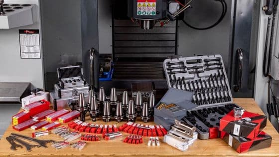 What Are Machine CNC Feeds and Speeds What They Really Mean for Cuts Various CNC machine tools and accessories displayed on a table in front of the machine. | Sky Rye Design Various CNC machine tools and accessories displayed on a table in front of the machine.
