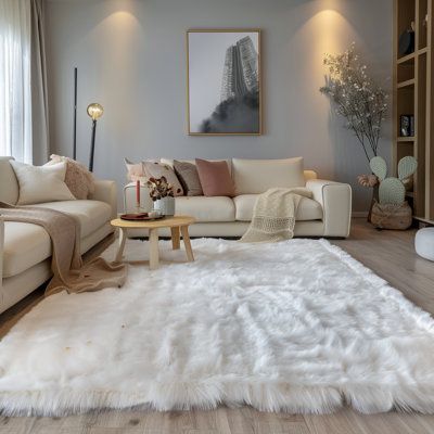 Cozy living room with a plush white rug, modern decor, and a comfy sofa. Warm lighting enhances the elegant ambiance.