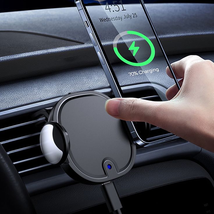 Hand placing smartphone on car wireless charger, phone displaying 70% charge status, mounted on air vent.