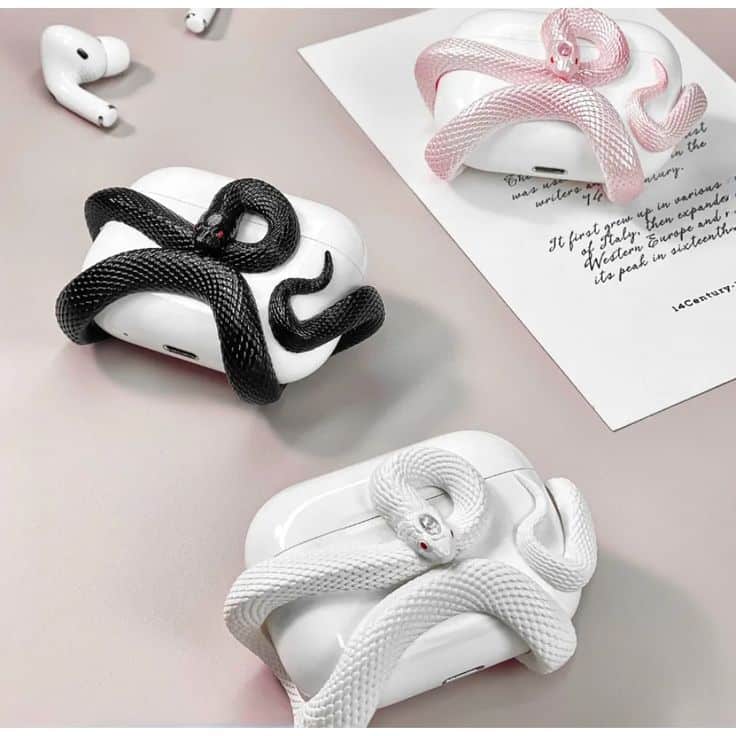 XASECASE Snake Design Earphones Protect Case EarPods Hard Cover Protector Decor Fit PVc for Air Pods Stylish AirPods cases with textured snake designs in black, white, and pink on a minimalist desk setup with earbuds. | Sky Rye Design Stylish AirPods cases with textured snake designs in black, white, and pink on a minimalist desk setup with earbuds.