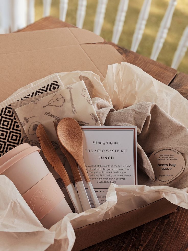 Zero Waste Lunch Kit Box - Best Eco Box by Mimi August Reusable coffee cup and ustencils and bento Eco-friendly zero waste kit featuring wooden utensils, reusable cup, beeswax wraps, and bento bag in a cardboard box with tissue paper. | Sky Rye Design Eco-friendly zero waste kit featuring wooden utensils, reusable cup, beeswax wraps, and bento bag in a cardboard box with tissue paper.