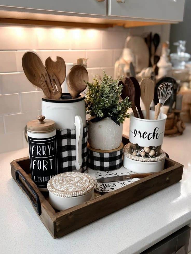 Rustic kitchen decor with wooden utensils, jars, and checkered fabric on a tray, adding a cozy touch to a modern countertop.