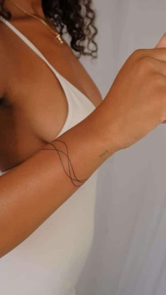 ac68f0767bb0d9206935a2ff83f7230b Minimalistic line art tattoo on a woman's arm with a white dress background. | Sky Rye Design Minimalistic line art tattoo on a woman's arm with a white dress background.