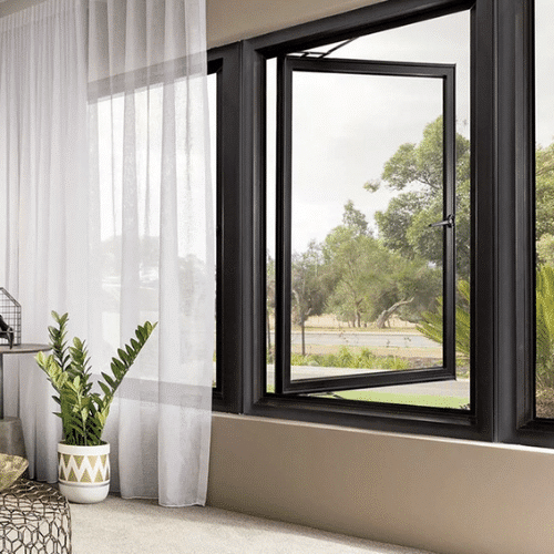Modern living room with open window, sheer curtains, light beige sofa, green plant, and decorative accessories, offering a serene view outside.