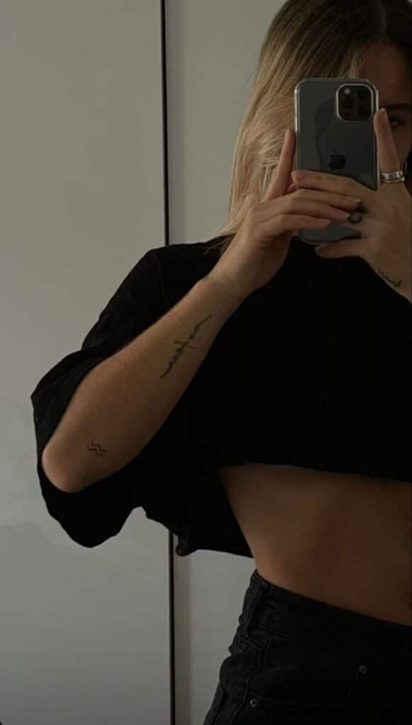 bab11ea39ecc59df6be293a17cedd80f Person taking a mirror selfie with tattoos visible on arms. Wearing a black crop top and holding a smartphone. | Sky Rye Design Person taking a mirror selfie with tattoos visible on arms. Wearing a black crop top and holding a smartphone.