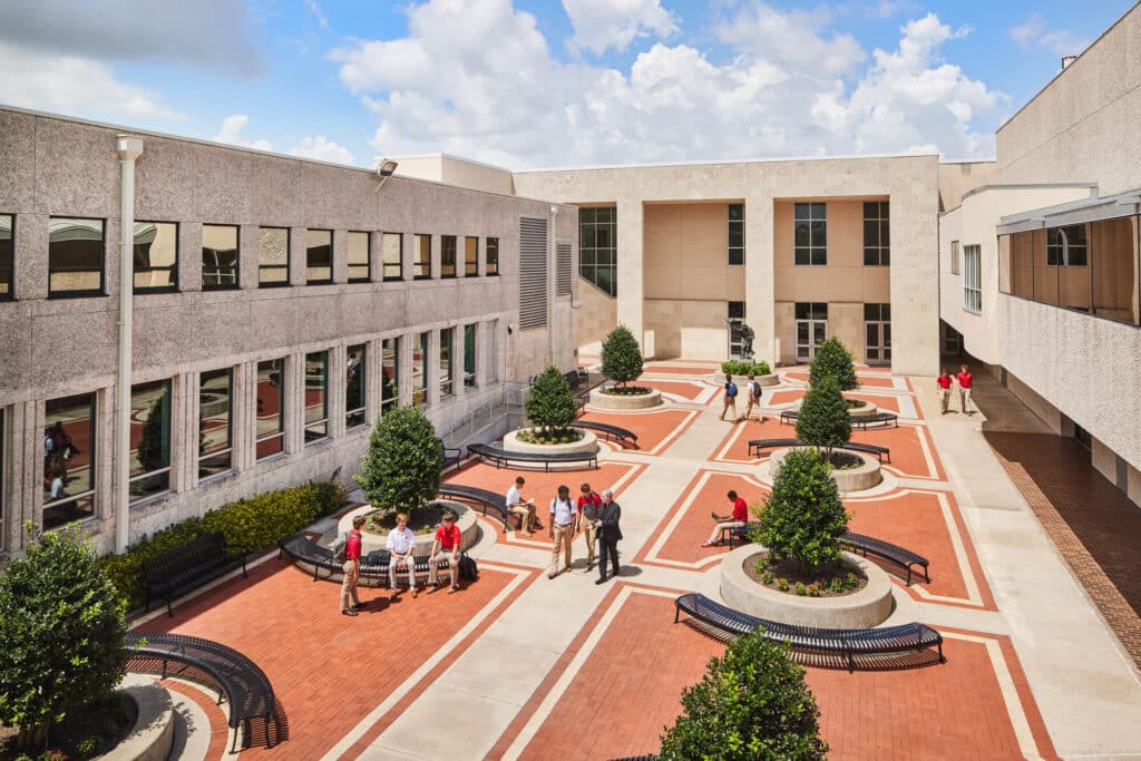 bg_courtyard-a Modern school courtyard with students socializing on brick pathways, surrounded by greenery, sunny day with blue sky and clouds. | Sky Rye Design Modern school courtyard with students socializing on brick pathways, surrounded by greenery, sunny day with blue sky and clouds.