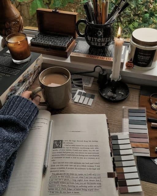 cdb0b0d44fb9097a6693e7490c4735c6 Cozy reading nook with candles, open book, and a warm mug of coffee. Creative ambiance with stationery and color swatches on a desk. | Sky Rye Design Cozy reading nook with candles, open book, and a warm mug of coffee. Creative ambiance with stationery and color swatches on a desk.