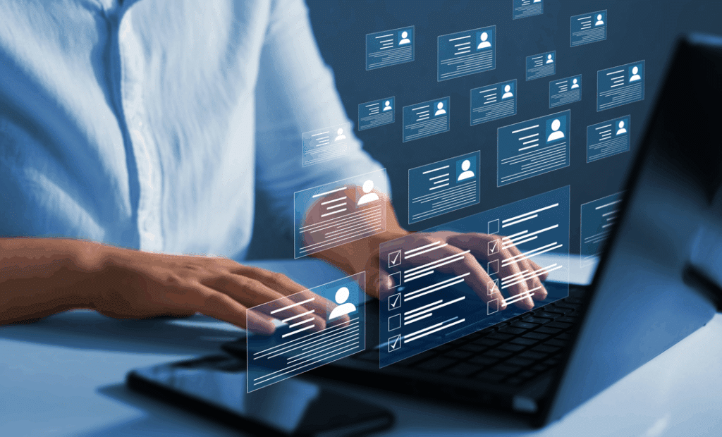 Person typing on a laptop with digital profiles and checklists floating above, representing online data management and digital networking.