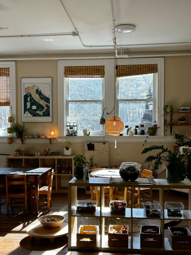 class time 📚👩_🏫 Cozy classroom with wooden furniture, plants, and natural light from large windows, creating an inviting learning environment. | Sky Rye Design Cozy classroom with wooden furniture, plants, and natural light from large windows, creating an inviting learning environment.