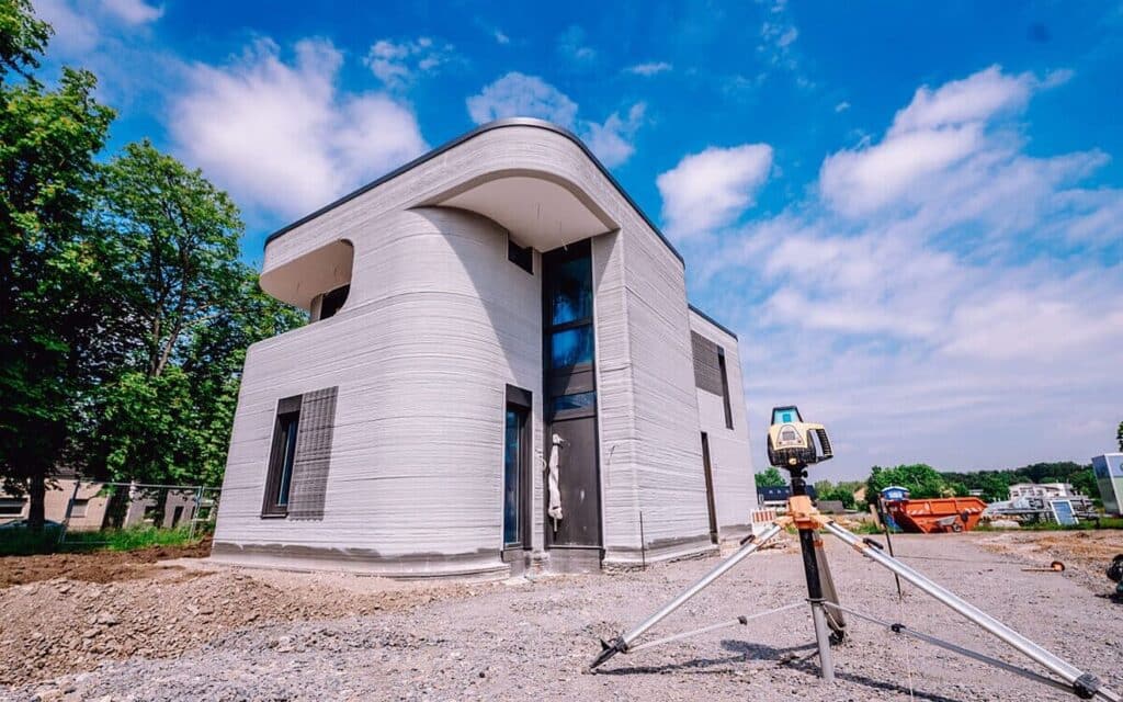 3D-printed modern house under construction with blue sky, showcasing innovative architecture and sustainable building technology.
