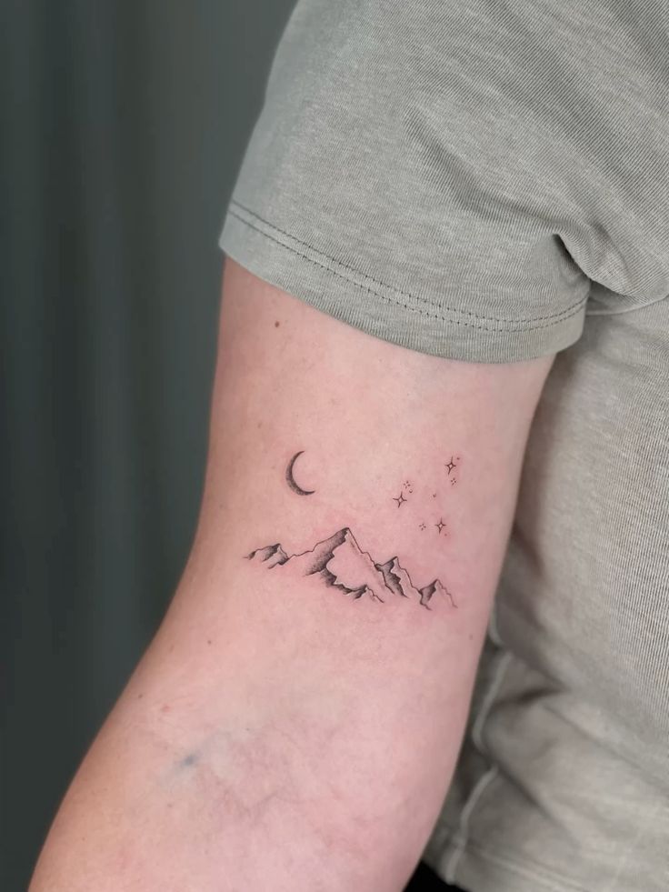 d4ebc50438c4d63d0b00de022050565b Minimalist mountain, moon, and star tattoo on upper arm under a gray sleeve. | Sky Rye Design Minimalist mountain, moon, and star tattoo on upper arm under a gray sleeve.