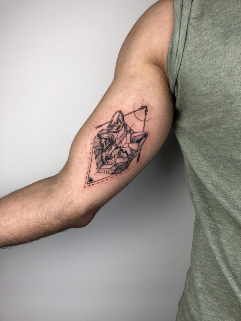 d74d46c7b829194ba63369e549eda63f Geometric wolf tattoo on man's arm in a sleeveless shirt, illustrating modern artistic design. | Sky Rye Design Geometric wolf tattoo on man's arm in a sleeveless shirt, illustrating modern artistic design.