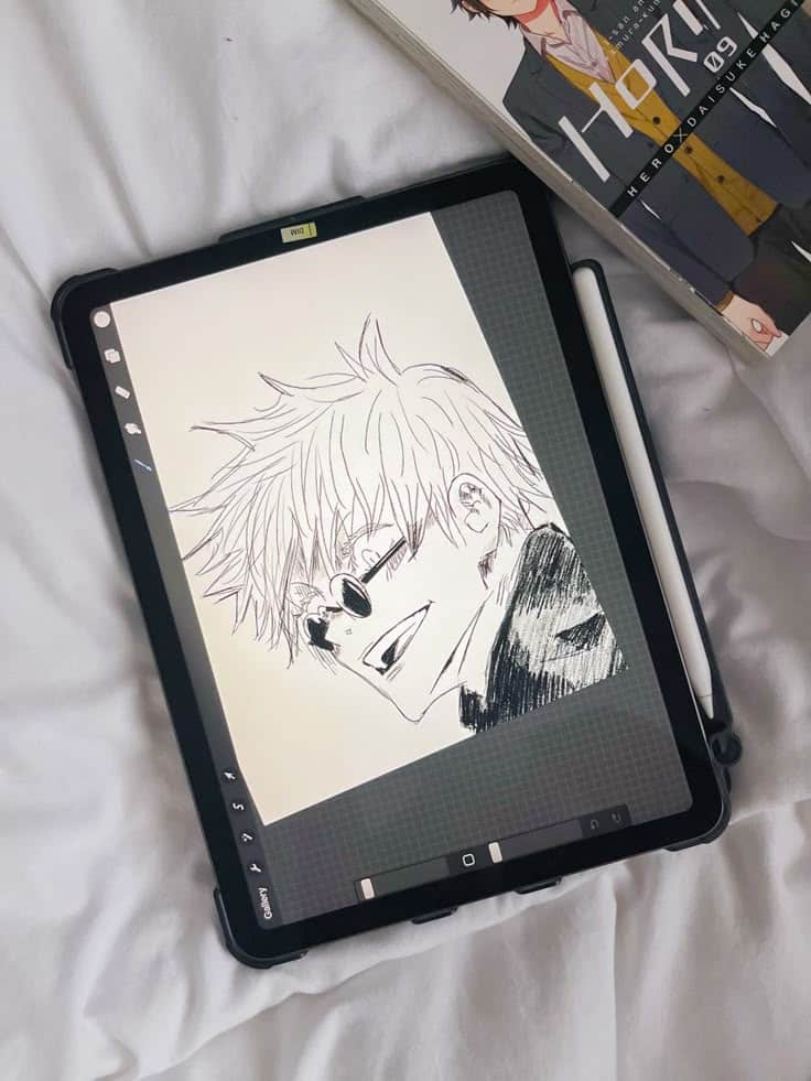 drawing Digital manga drawing on tablet with stylus, next to a manga book on a white fabric background. | Sky Rye Design Digital manga drawing on tablet with stylus, next to a manga book on a white fabric background.