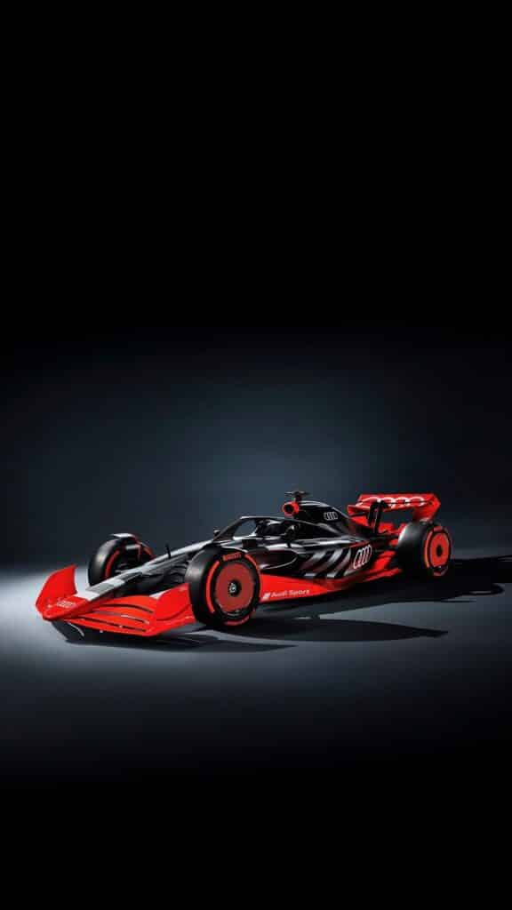 Sleek red and black Formula 1 car on display, showcasing advanced aerodynamic design and Audi branding on a dark background.