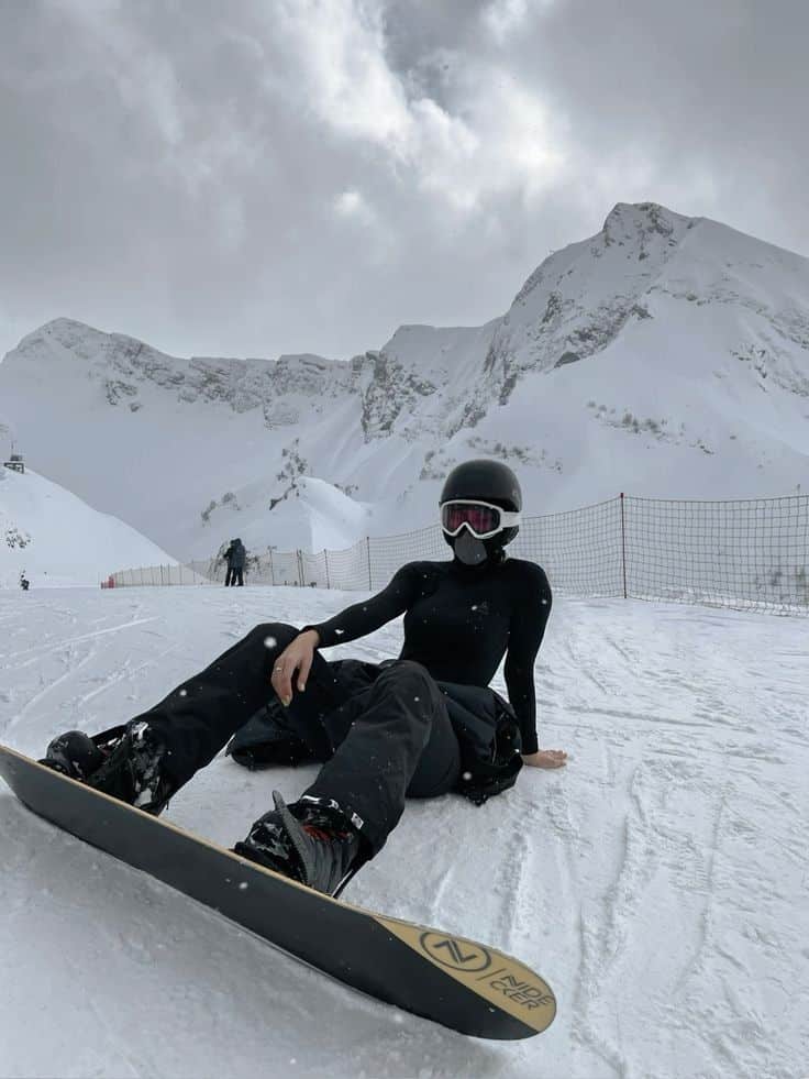 effdeesea ✨ Snowboarder resting on a snowy mountain slope, mountains in the background, wearing black gear and goggles, winter sports scene. | Sky Rye Design Snowboarder resting on a snowy mountain slope, mountains in the background, wearing black gear and goggles, winter sports scene.
