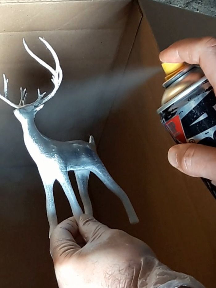 f5b40b3b9ce5ed23b8f64b4588f9fe54 Spray painting a reindeer figurine silver inside a cardboard box for a DIY craft project. | Sky Rye Design Spray painting a reindeer figurine silver inside a cardboard box for a DIY craft project.