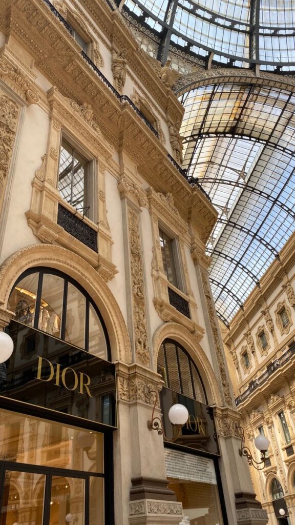 fgbxdg Luxury Dior storefront in ornate shopping arcade with glass ceiling, elegant architecture in a historic setting. | Sky Rye Design Luxury Dior storefront in ornate shopping arcade with glass ceiling, elegant architecture in a historic setting.