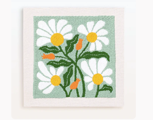Embroidered floral artwork featuring white daisies with yellow centers and green leaves on a soft green background.